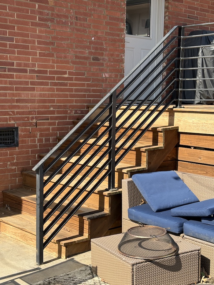 outdoor wooden stairway with iron railing.